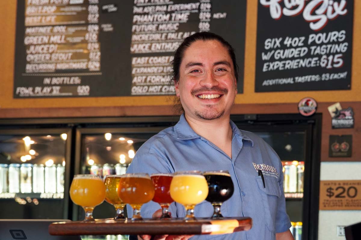 Bartender holding a flight of beers